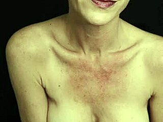 Kiki Deez cu sânii mari și părul scurt într-un videoclip solo fumător