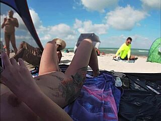 Voyeurismus na pláži s nahou ženou a několika muži, kteří se dívají