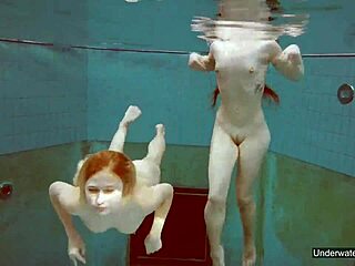 Två fantastiska tjejer simmar i poolen och leker med sina kroppar